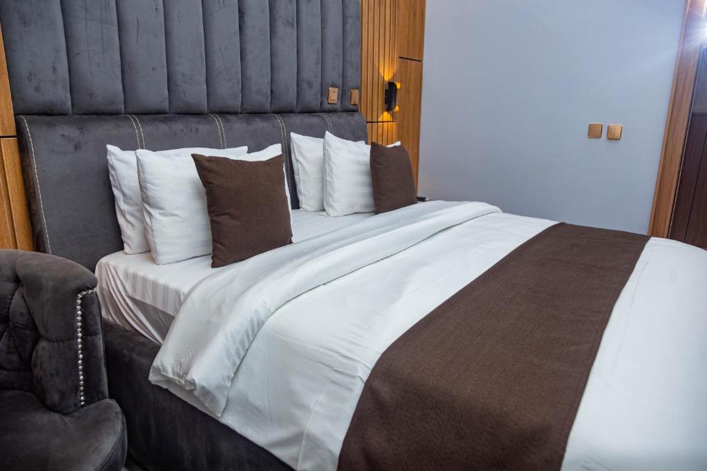 a bedroom with a large bed with pillows at Cardiff Resort in Makurdu
