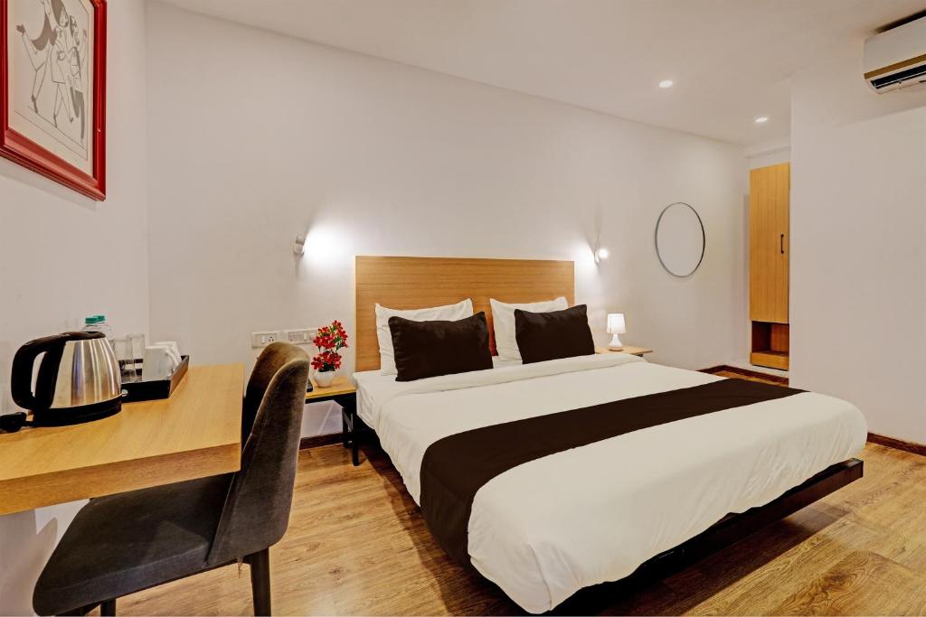a hotel room with a bed and a desk with a desk at Super Townhouse Ramamurthy Nagar Formerly Navya International in Bengaluru