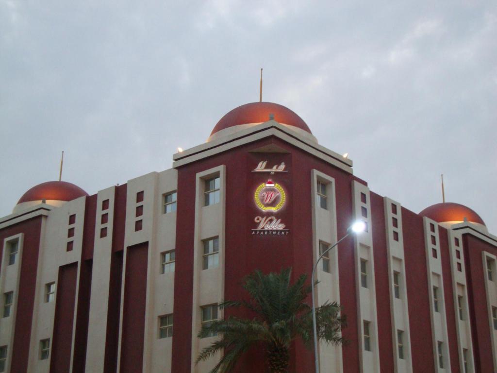 a building with a clock on the top of it at Villa Hotel Apartments Al Khobar in Al Khobar