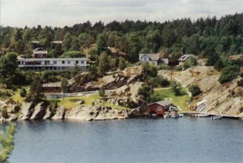 a house on a hill next to a body of water at Sjøverstø Holiday in Tvedestrand