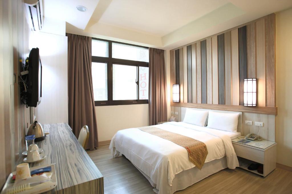 pokój hotelowy z łóżkiem i telewizorem w obiekcie Chengdian Hotel w Tajpej