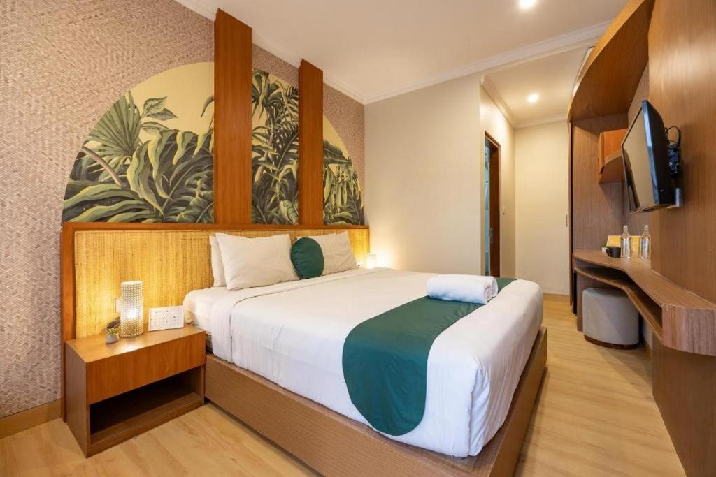 a hotel room with a large bed and a television at Cove Vin Stay Petanu in Pesanggaran