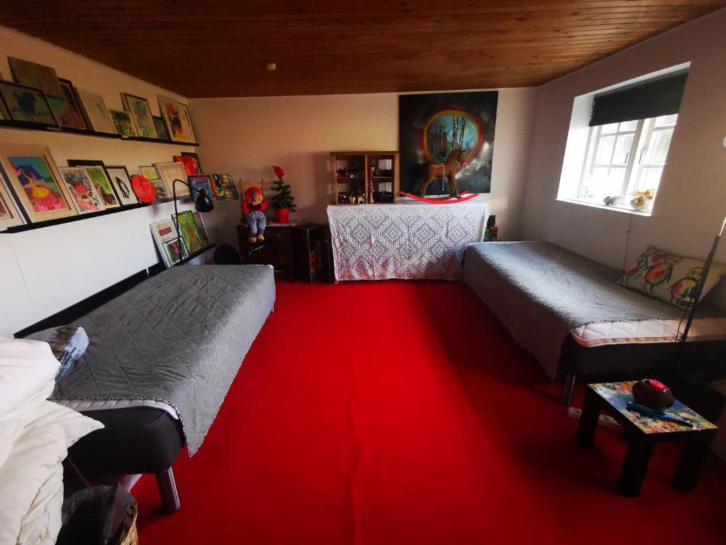 a bedroom with two beds and a red carpet at Den gamle smedie in Holbæk