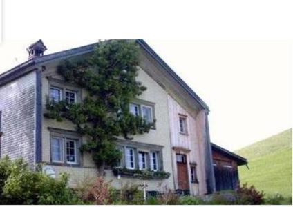 una casa con un árbol creciendo a su lado en Ferienhaus Brand, en Gais