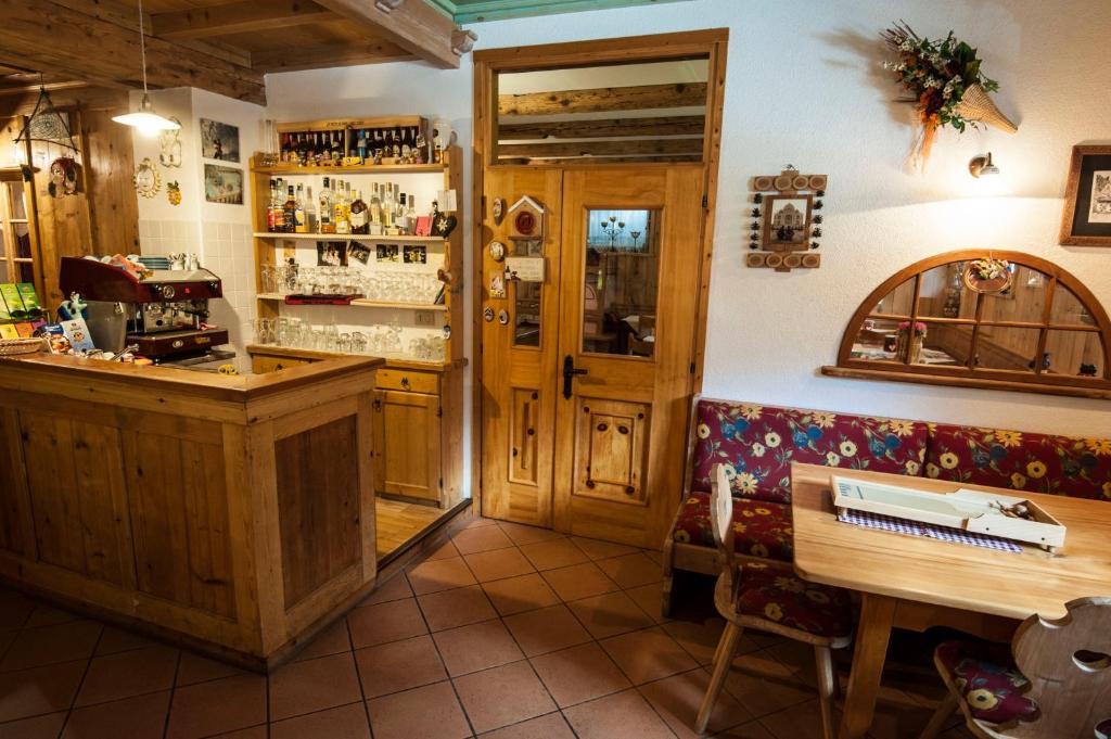 bar z ławką i stołem w pokoju w obiekcie B&B Col Da La Vila w mieście Canazei