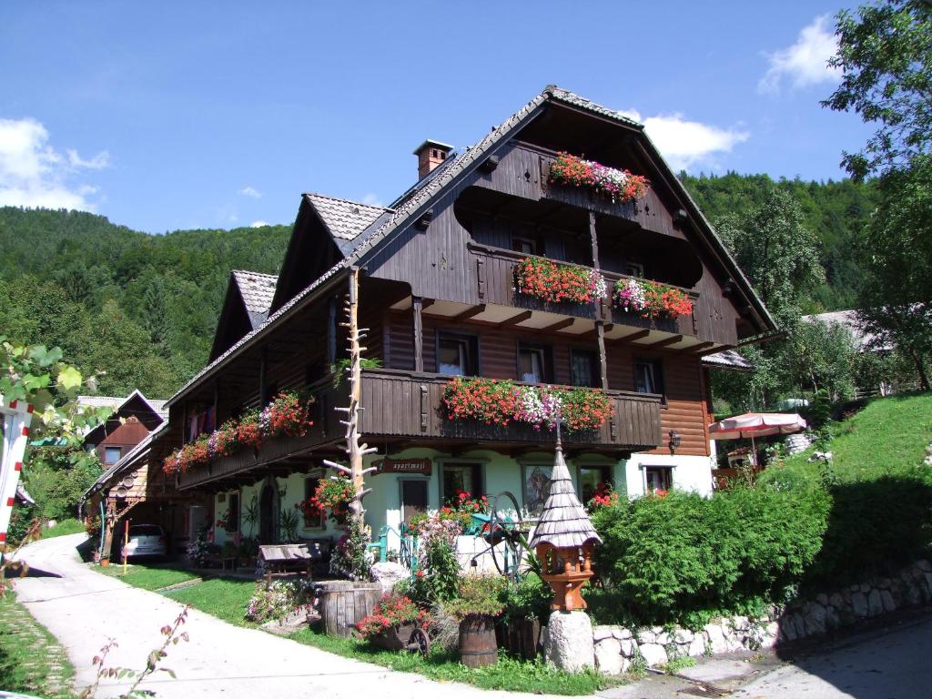 una casa con flores en la parte delantera en Apartments Sodja, en Bohinj