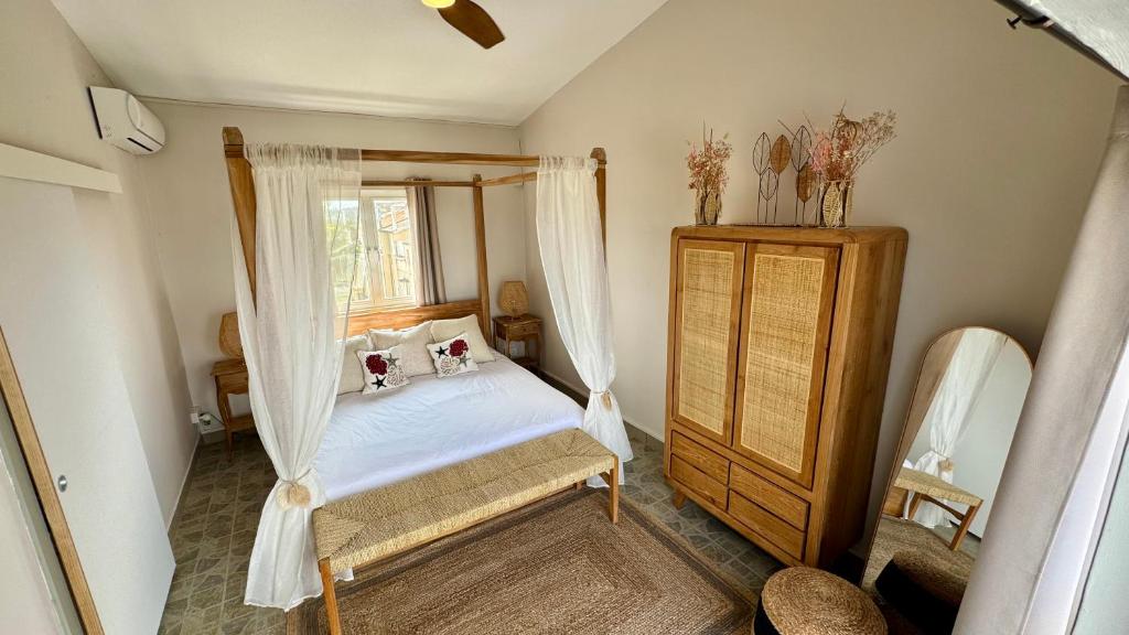 une chambre avec un lit à baldaquin et une fenêtre dans l'établissement Zephyr House 3BR Pool, Rooftop & Ocean View, à Grand Gaube