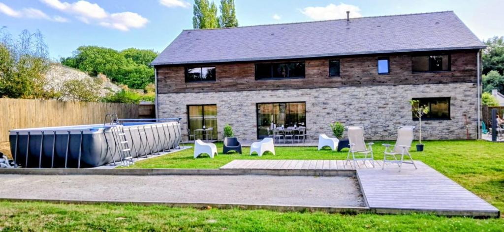 ein Haus mit Stühlen im Hof davor in der Unterkunft Chambres d'hôtes ''La Clairière aux Chênes'' in Treillières