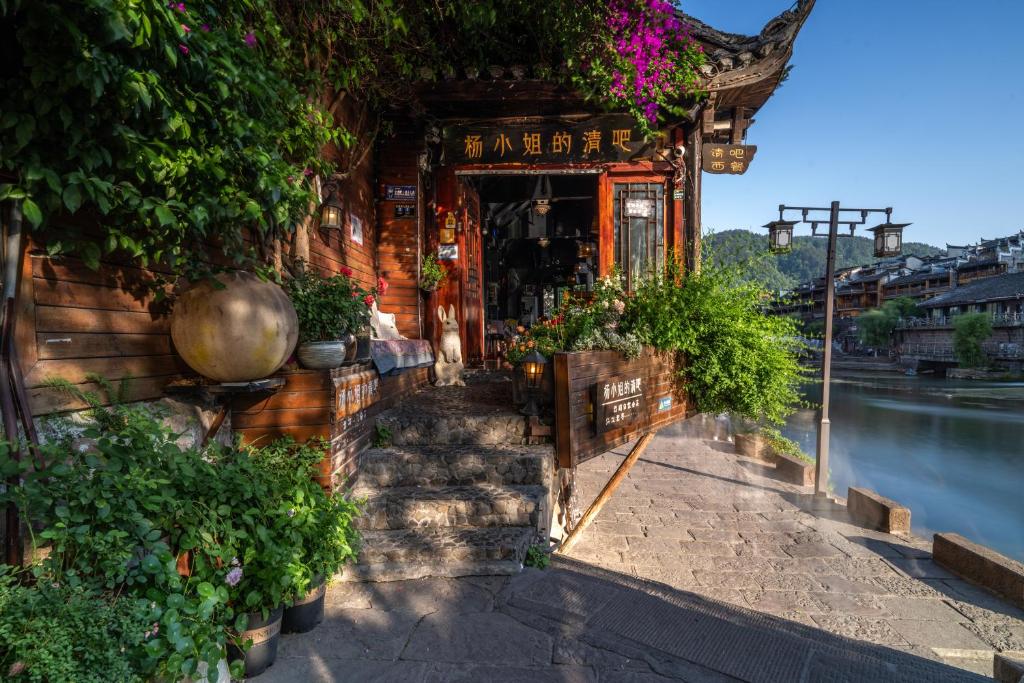 ein Gebäude mit Pflanzen an der Seite in der Unterkunft Fenghuang Luming B&B in Fenghuang