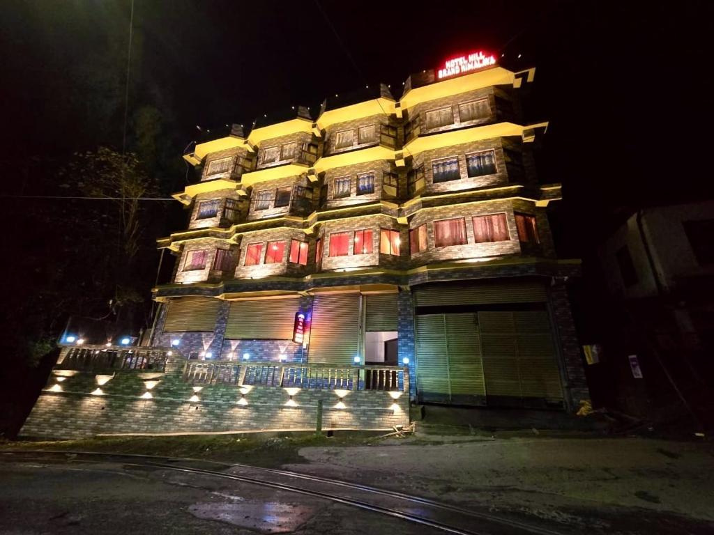 a tall building with lights on it at night at Hotel Hill Grand Himalaya in Darjeeling