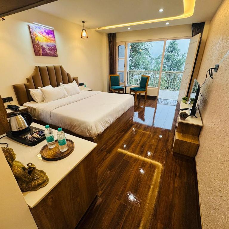 a hotel room with a bed and a desk with a television at Jasmine Mountain View Retreat - Mall Road Dalhousie in Dalhousie