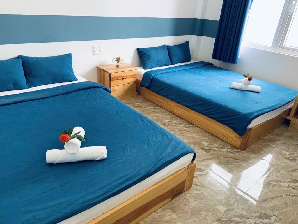una camera da letto con due letti con sopra degli animali di peluche di August Inn Da Lat a Da Lat