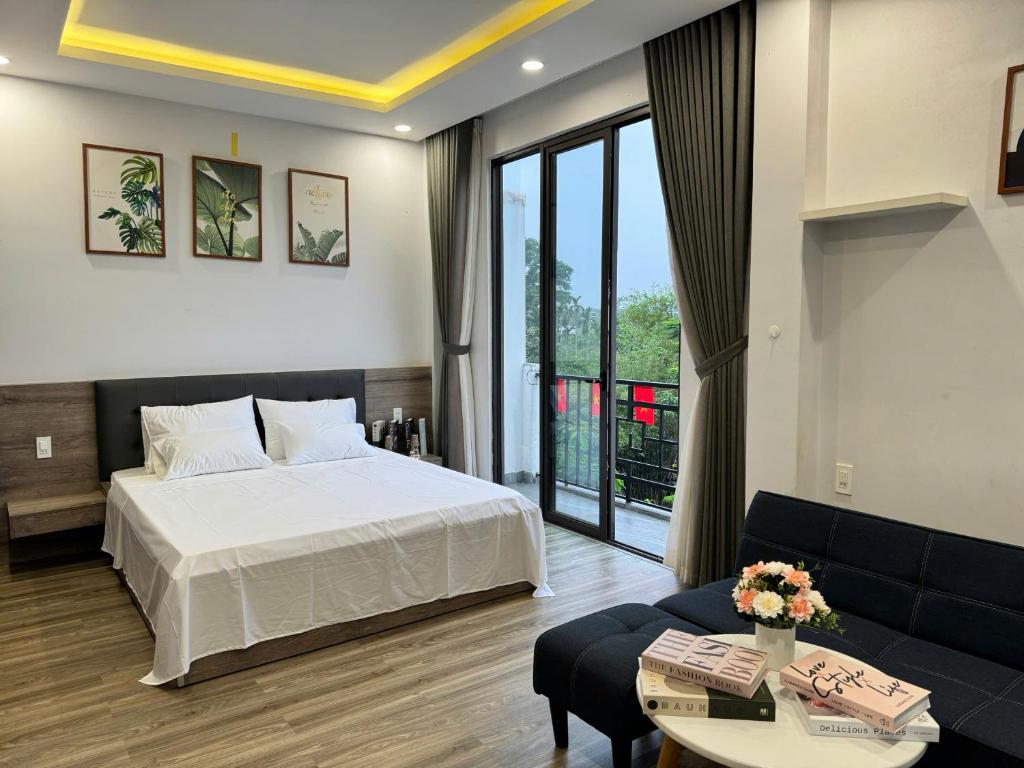 ein Hotelzimmer mit einem Bett und einer Couch in der Unterkunft Bliss Homestay Huế in Thôn Lại Thê