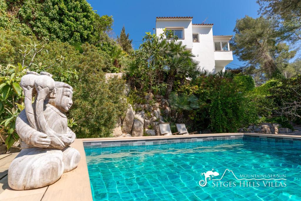 eine Statue neben einem Pool in der Unterkunft Casa Sian Retreat near Sitges in Olivella