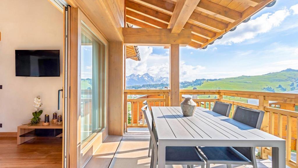 a dining room with a table and views of mountains at ASAI210-10-1 - Appartement 4 étoiles - Les Saisies - 6 personnes in Les Saisies