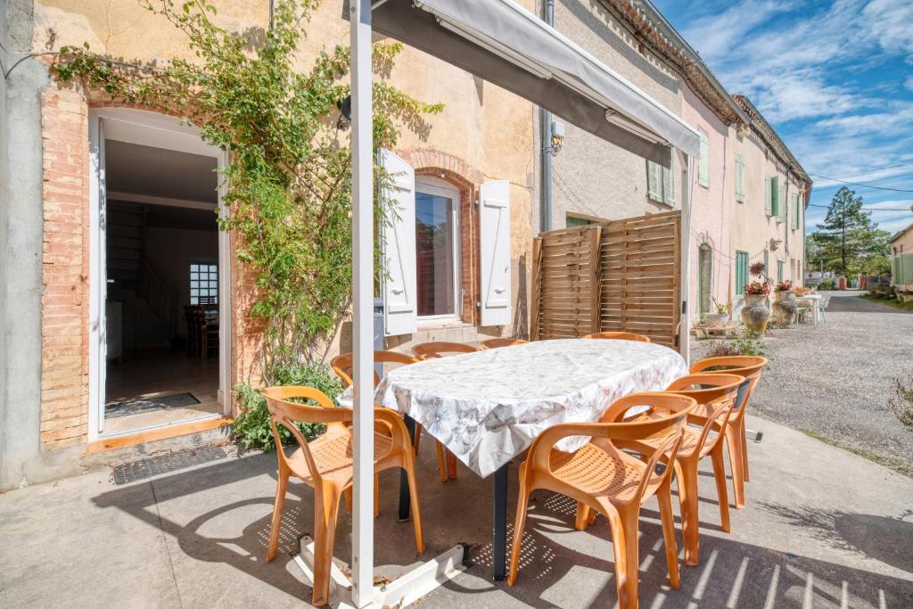 a table and chairs on the patio of a house at Gîte Le Rosier - Gîte À La Ferme 
