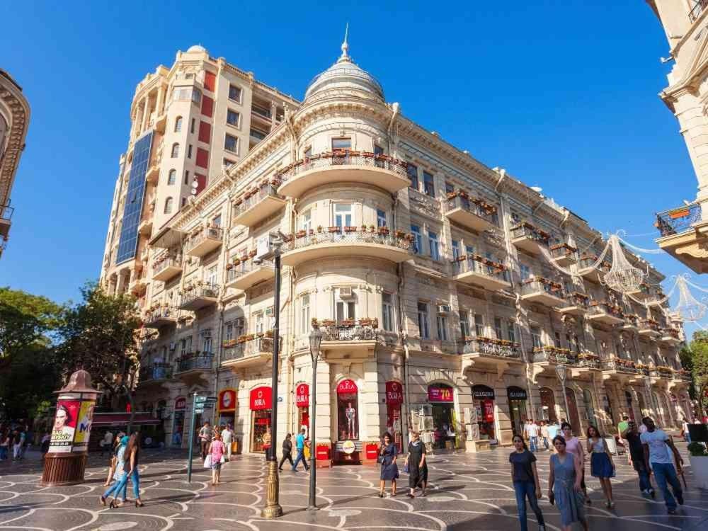 a large building with people walking in front of it at Cozy Apart in Center in Baku