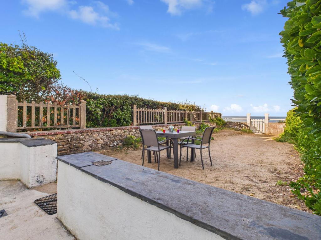 a table and chairs on a patio with the beach at Maison avec accès privatif direct à la plage pour 6 in Pornichet