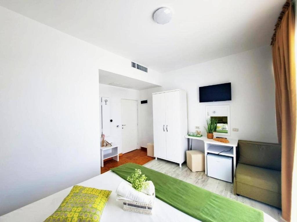 une chambre avec un lit et un canapé dans une pièce dans l'établissement Tasos - Rooms with see View, à Eforie Nord