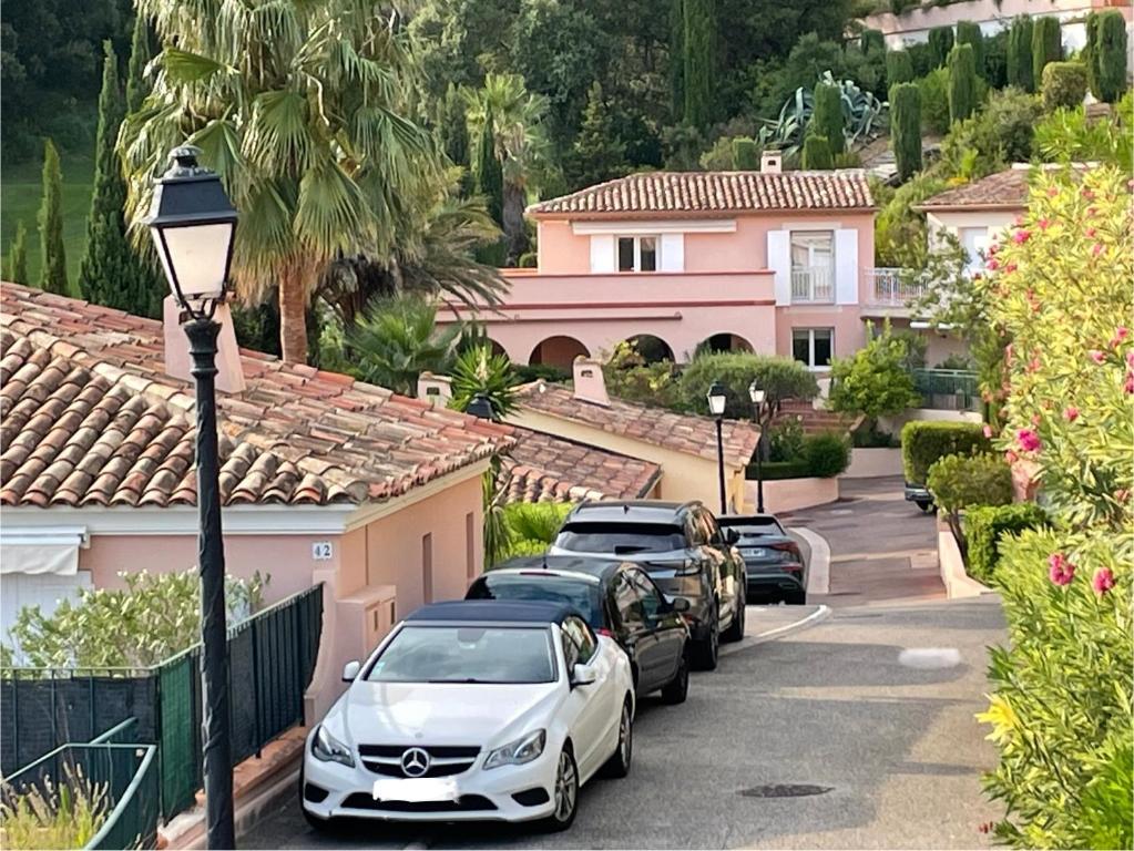 eine Reihe von Autos, die vor einem Haus geparkt sind in der Unterkunft Villa 49 Hameau des Greens in Sainte-Maxime