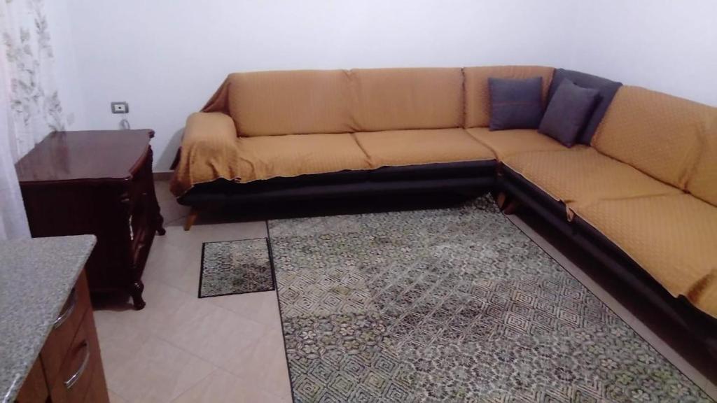 a brown couch in a living room with a table at Kukesi Center Apartments in Kukës