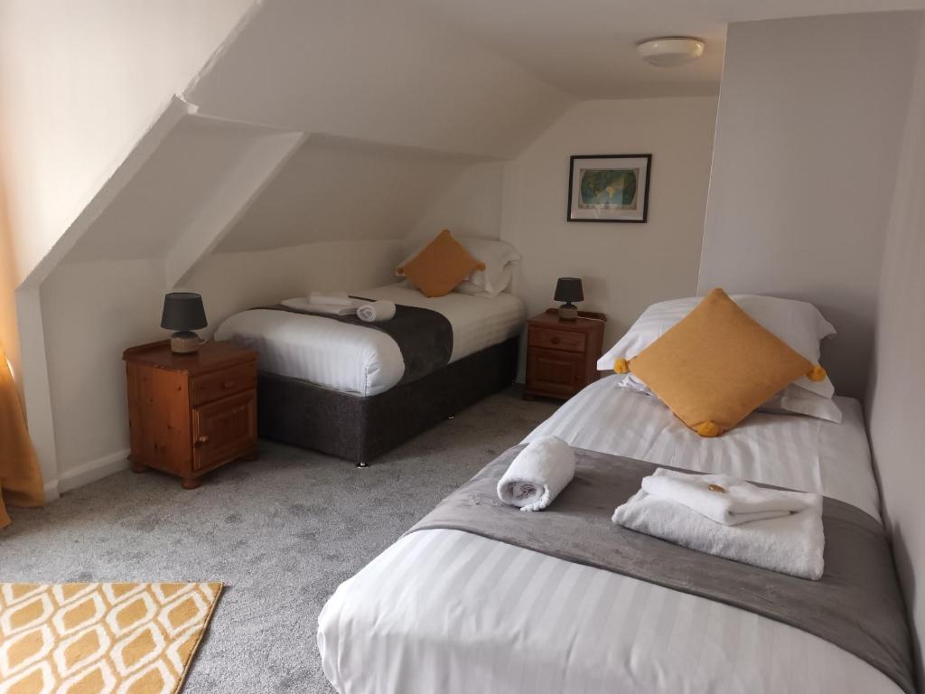 een slaapkamer met twee bedden en twee nachtkastjes bij The City Hotel in Durham