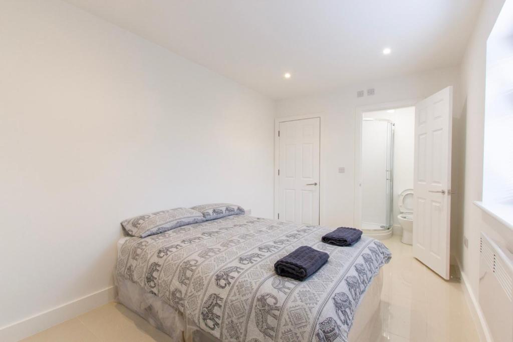 a white bedroom with a bed with two towels on it at Radstock Road - Room 2a in Southampton
