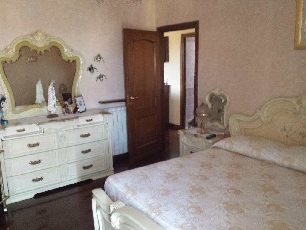 Un dormitorio con una cama, una cómoda y un espejo. en The green house, en Roma