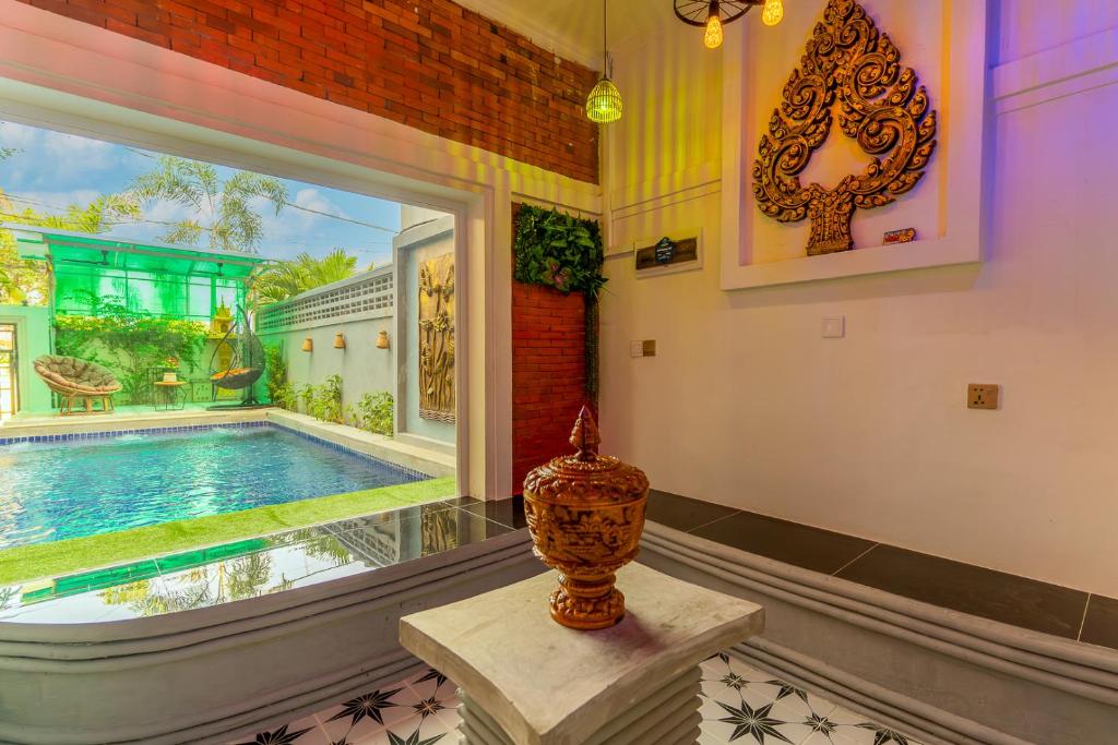 a home with a swimming pool and a window at Angkor Rithy Residences in Siem Reap