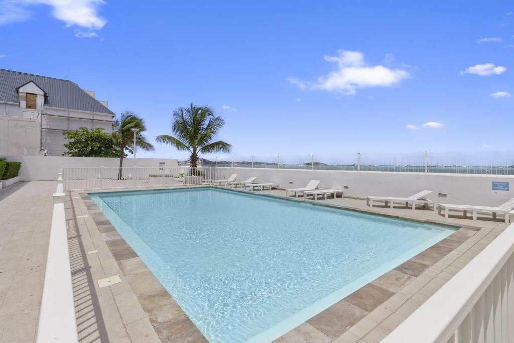 a swimming pool with chaise lounge chairs and a beach at Marigot Bay in Saint Martin
