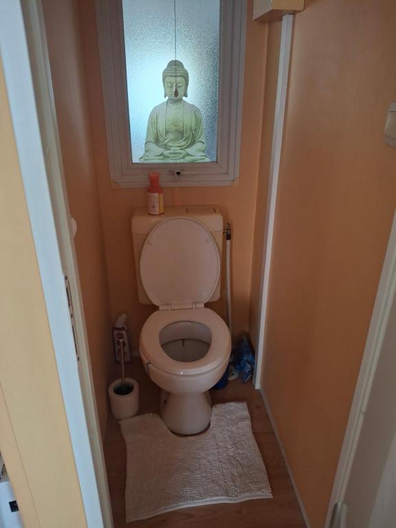 a bathroom with a toilet with a statue above it at Mobile Home 40m2 6 personnes in Saint-Étienne-de-Chigny