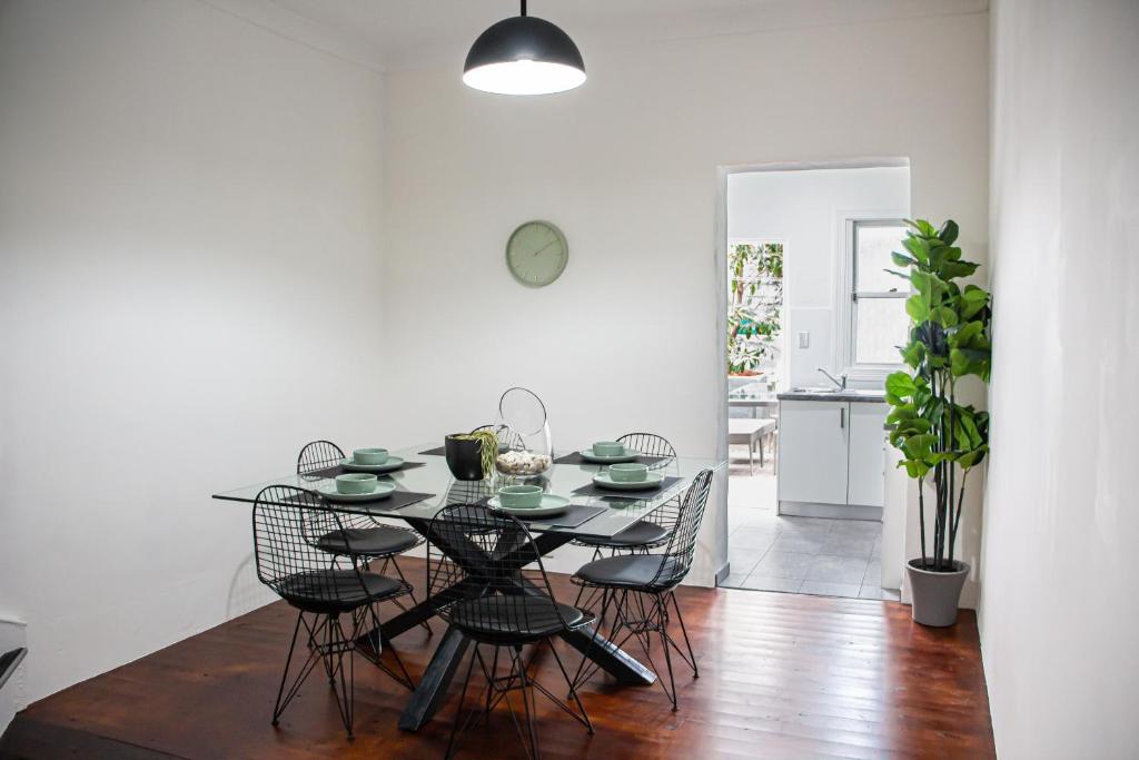 een eetkamer met een tafel en stoelen bij Cozy City House in the Heart of Paddington in Sydney
