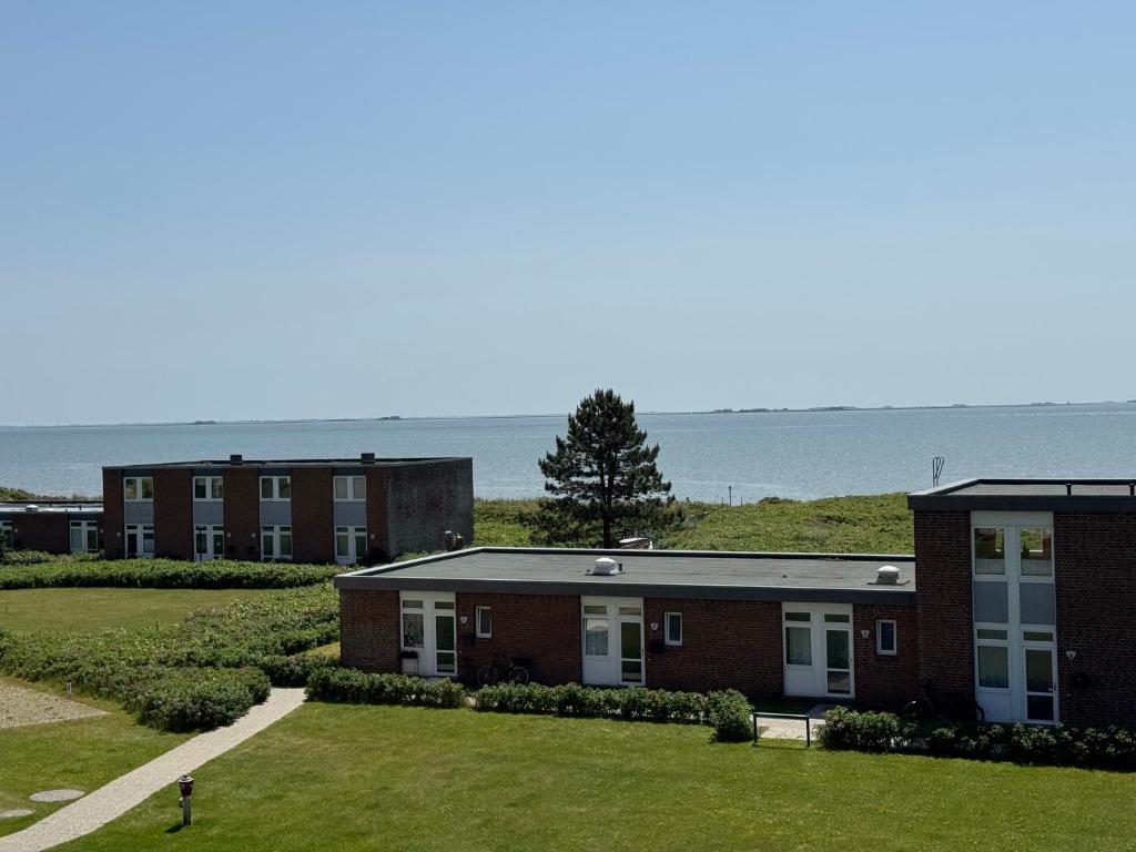 a row of brick buildings with the ocean in the background at Wellenkieker in Wyk auf Föhr