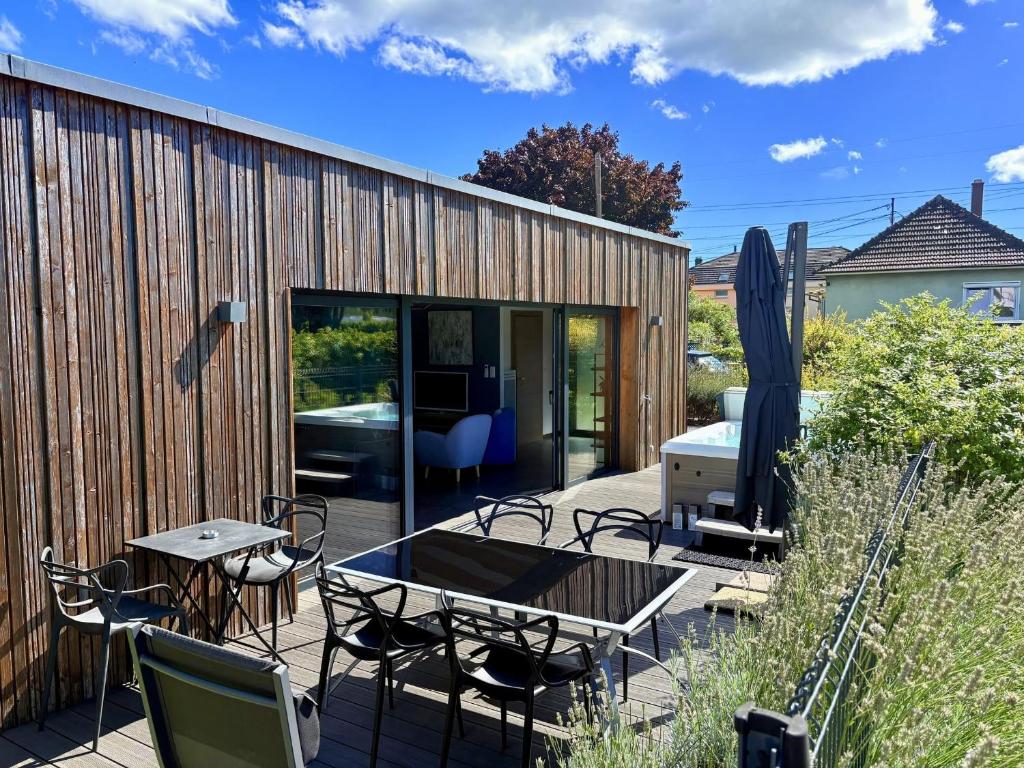 a patio with a table and chairs and a building at Sweet Escape et Spa in Turckheim