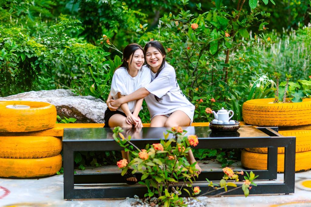 twee vrouwen zitten op een tafel in een tuin bij Song Toan Hotel in Phong Nha