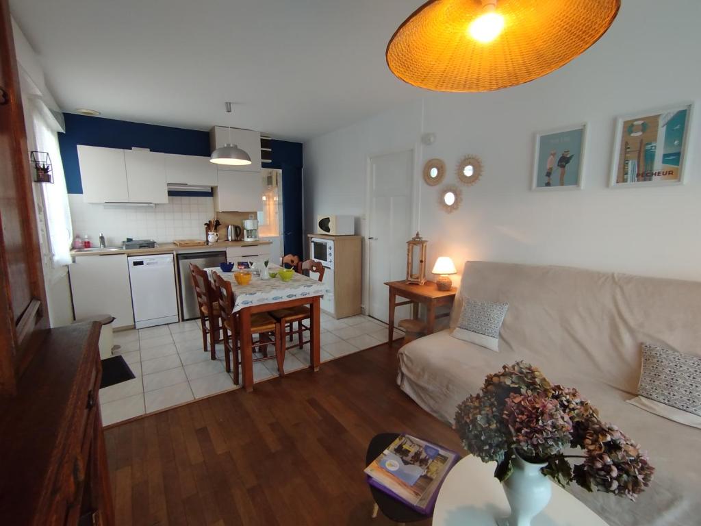 a living room and kitchen with a couch and a table at gite notre désir 100 m de la mer in Jullouville-les-Pins