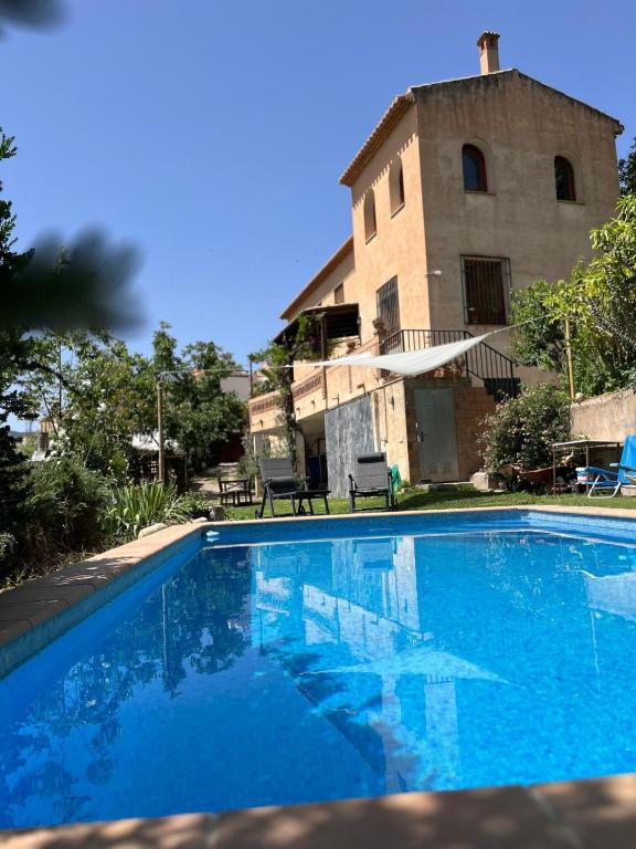 a blue swimming pool in front of a building at La Kamareta de Chite in Granada
