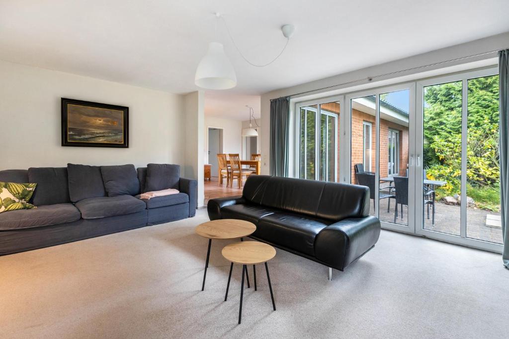 a living room with a black leather couch and a table at Ferienhaus Sprante in Brunsbüttel