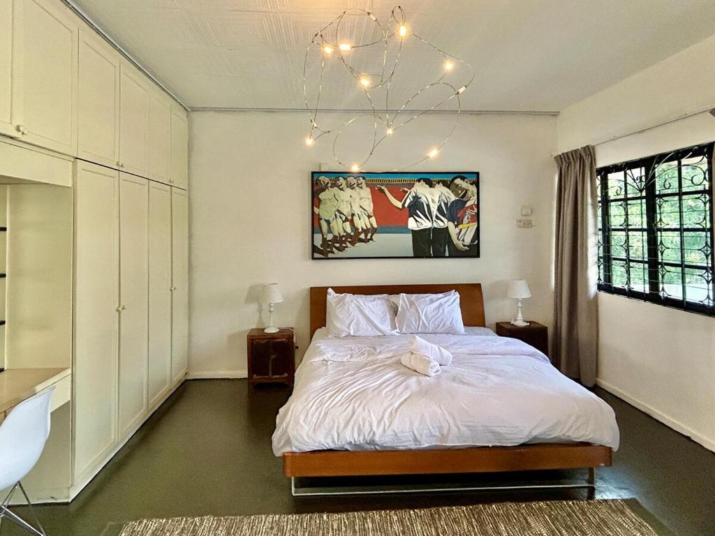 a bedroom with a bed and a chandelier at Cozy family Homestay Suite in Shared Bungalow SS2 PJ in Petaling Jaya