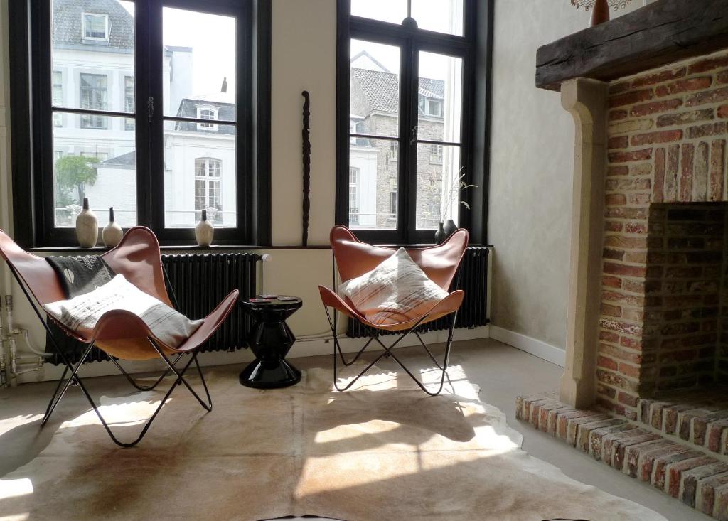 two chairs sitting in a room with windows at The Doghouse B&B in Bruges