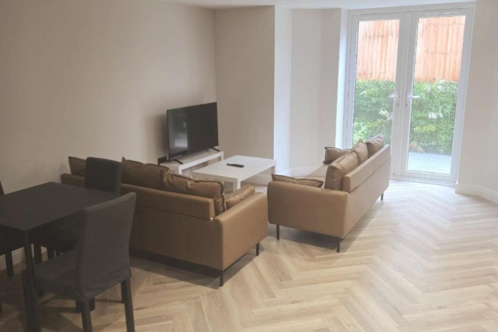イーストボーンにあるCharming 1-Bed Retreat with Patio: Cozy & Centralのソファとテーブルのあるリビングルーム
