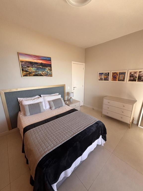 a bedroom with a bed and a painting on the wall at Apto frente praia-AlfaPark-Barra da Tijuca in Rio de Janeiro