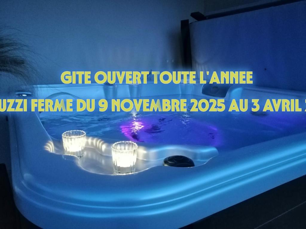 a blue tub with candles in it with a sign on it at Gîtes Les Nogalies SPA PRIVATIF in Valojoulx