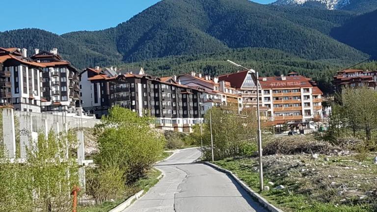 a winding road in front of a city with buildings at St Ivan Rilski Free SPA Luxury Apartment Bansko in Bansko