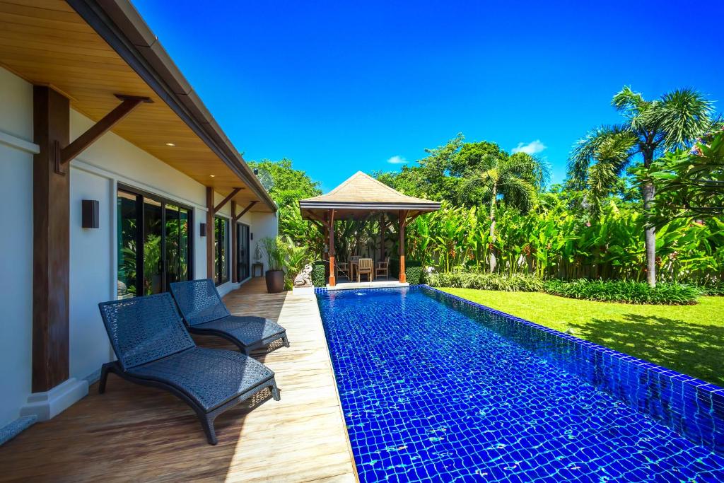 a swimming pool in a house with two chairs and a gazebo at Villa Haeata | Gorgeous 3 bedroom villa in the secured residence in Nai Harn Beach
