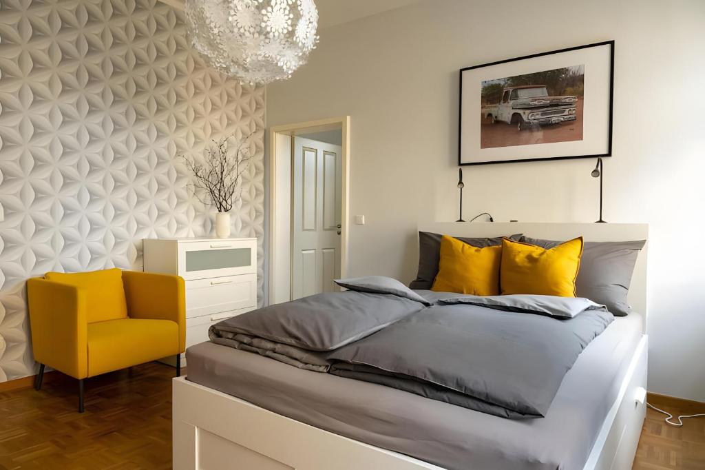 Un dormitorio con una cama y una silla amarilla. en Ferienwohnung Lindner 1, en Weimar