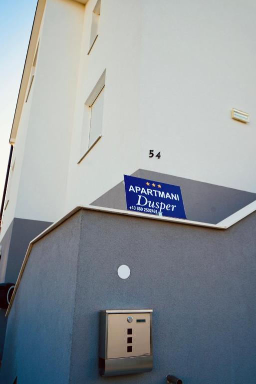 a blue street sign on the side of a building at Apartmani Dusper in Vodice