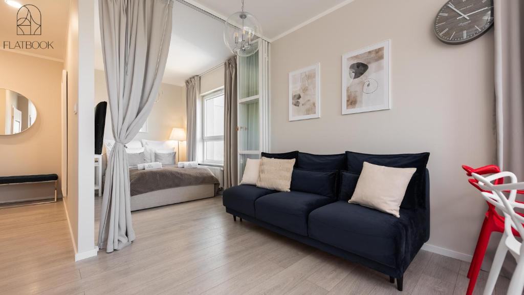 a living room with a couch and a bed at Flatbook Seaside Baltica Tower - Apartment with Sea View, Gym & Parking in Gdańsk