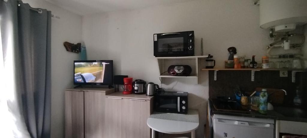 a kitchen with two televisions and a tv on the wall at Studio calme in Saint-Nazaire