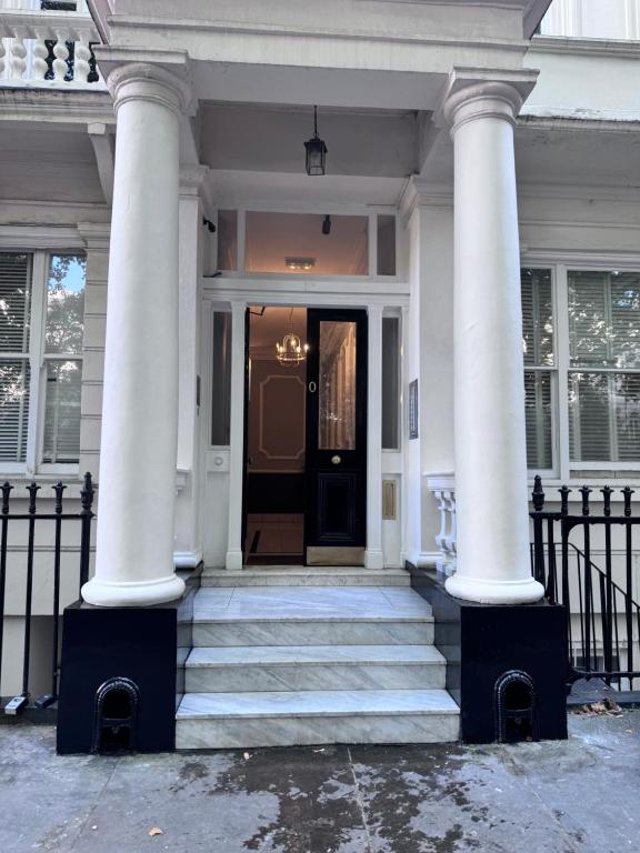 a white house with two columns and a front door at Regency Haven in London